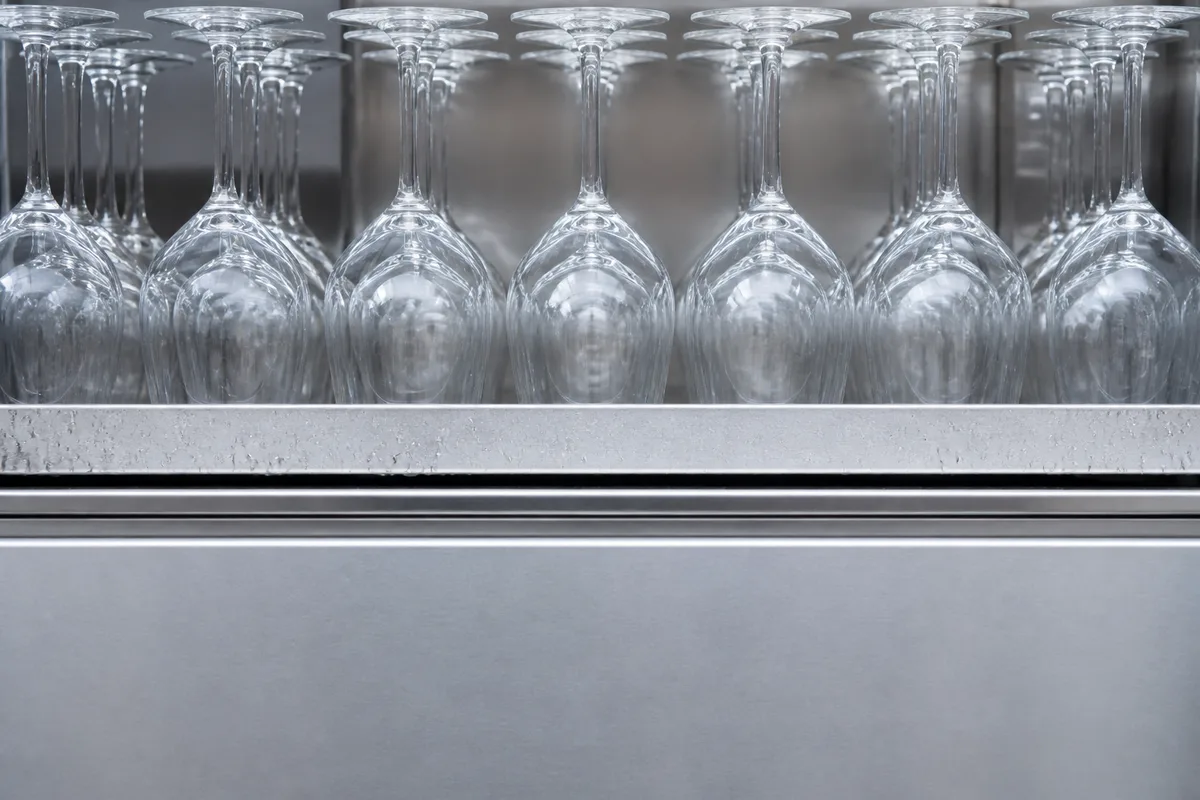 Mains versant une bière pression dans un verre incliné sous une colonne de tirage